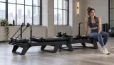 Black Carriage One family reformer with a Pilates instructor in a commercial studio