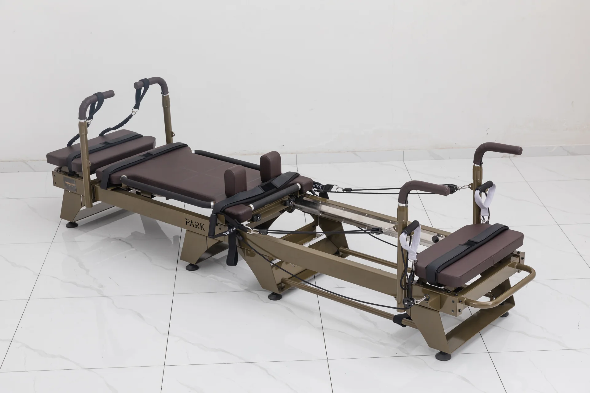 Carriage One full-size reformer with brown upholstery, platforms and raised handles