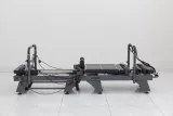 Side view of the Carriage One S compact reformer with grey upholstery