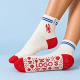 Cream lobster grip socks with red heel and toe, cobalt cuff stripes, motif artwork, and LOGO sole grip