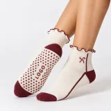 Ivory ruffle-ankle grip socks with burgundy trim, bow motif, and a LOGO sole grip