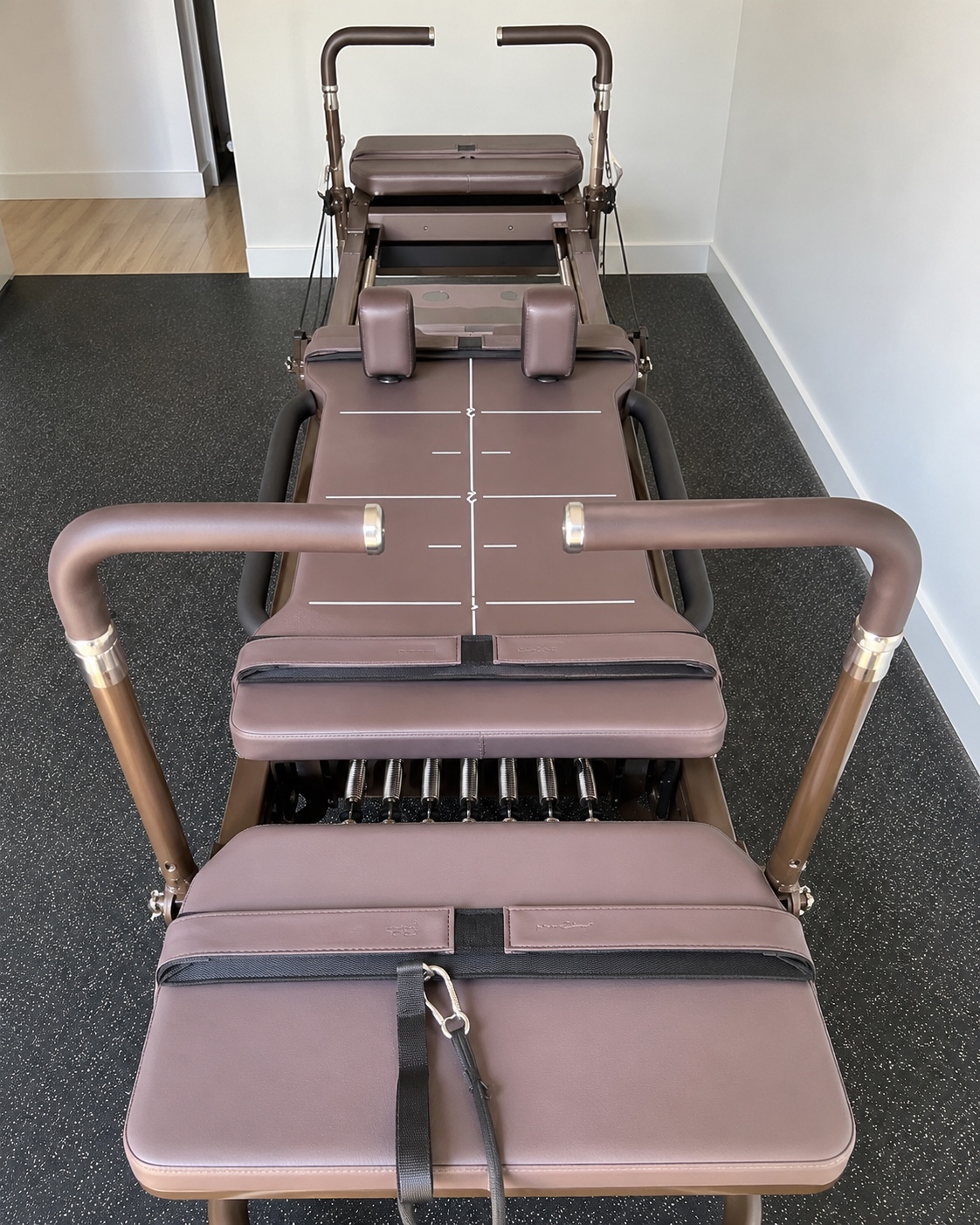 Full-length brown-upholstered Carriage One viewed from above in a studio room