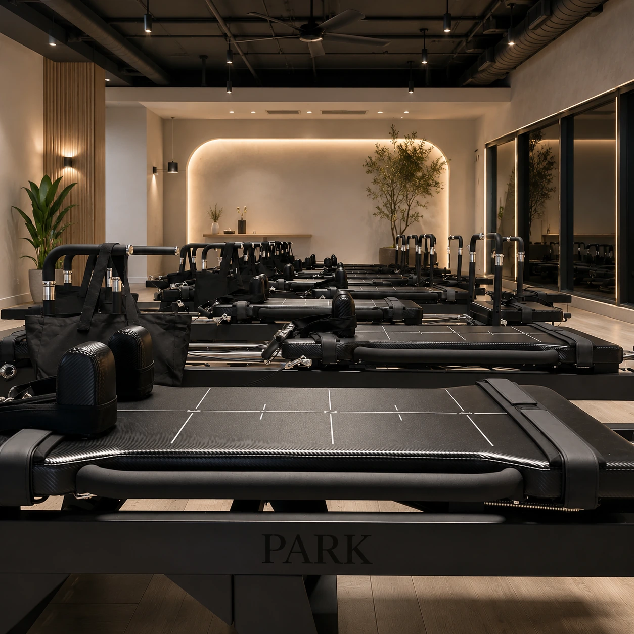 Warm commercial studio with rows of black high-intensity reformers