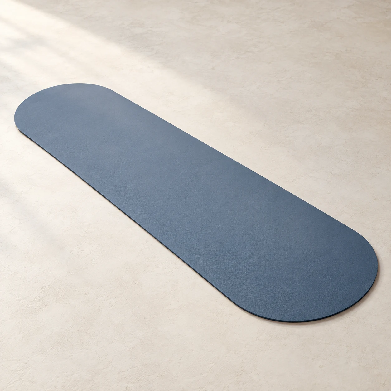 AI-generated slate-blue semi-oval studio mat concept with straight long sides and rounded ends on an ivory surface